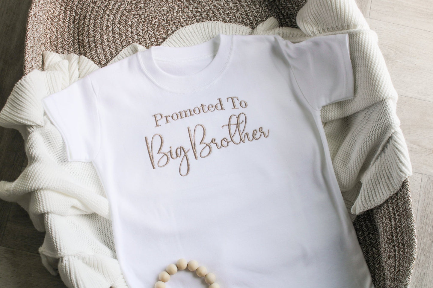 Children's t-shirt displaying 'promoted to big brother' across the chest