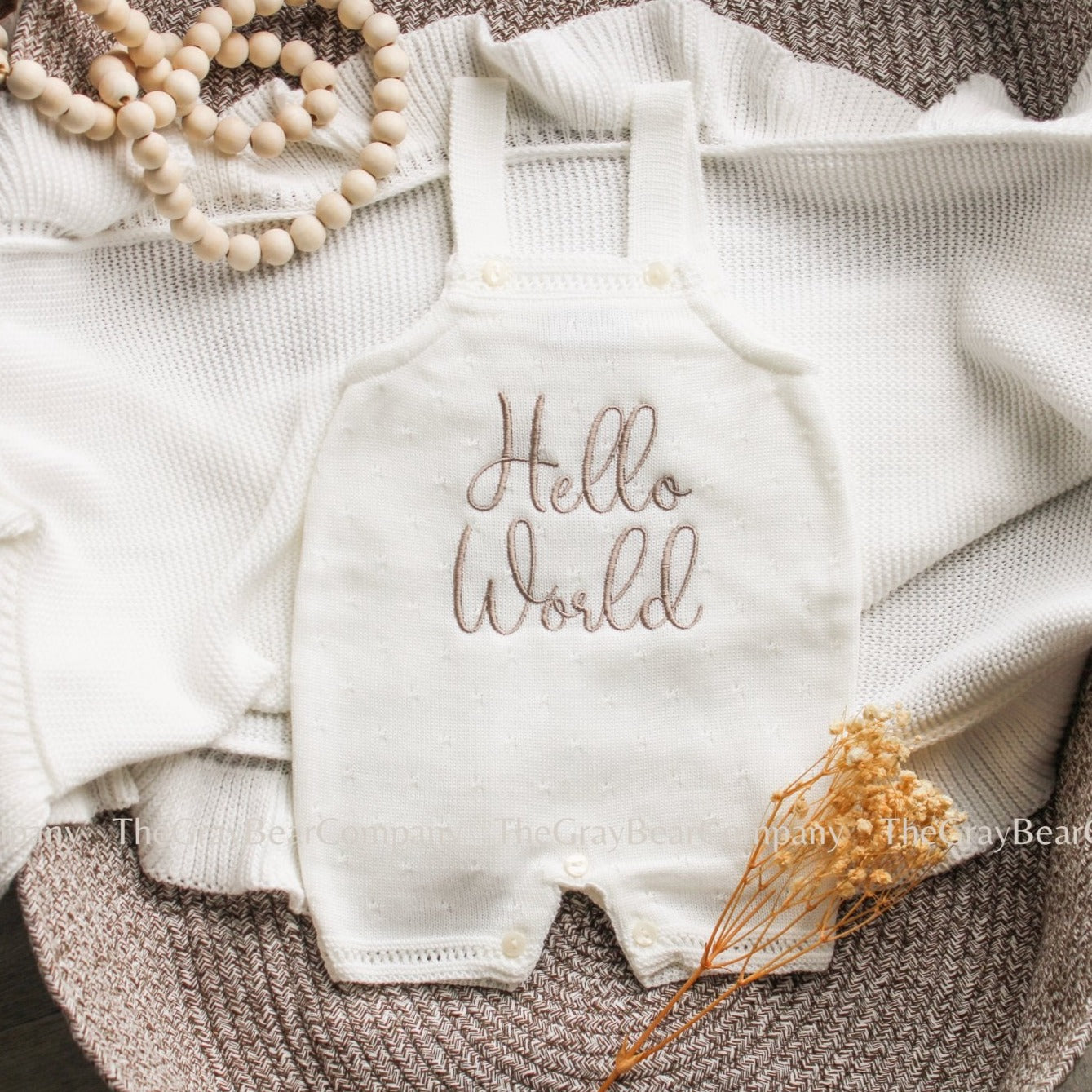 Hello world baby short sleeved romper. ivory colour with a soft brown embroidered phrase. 
